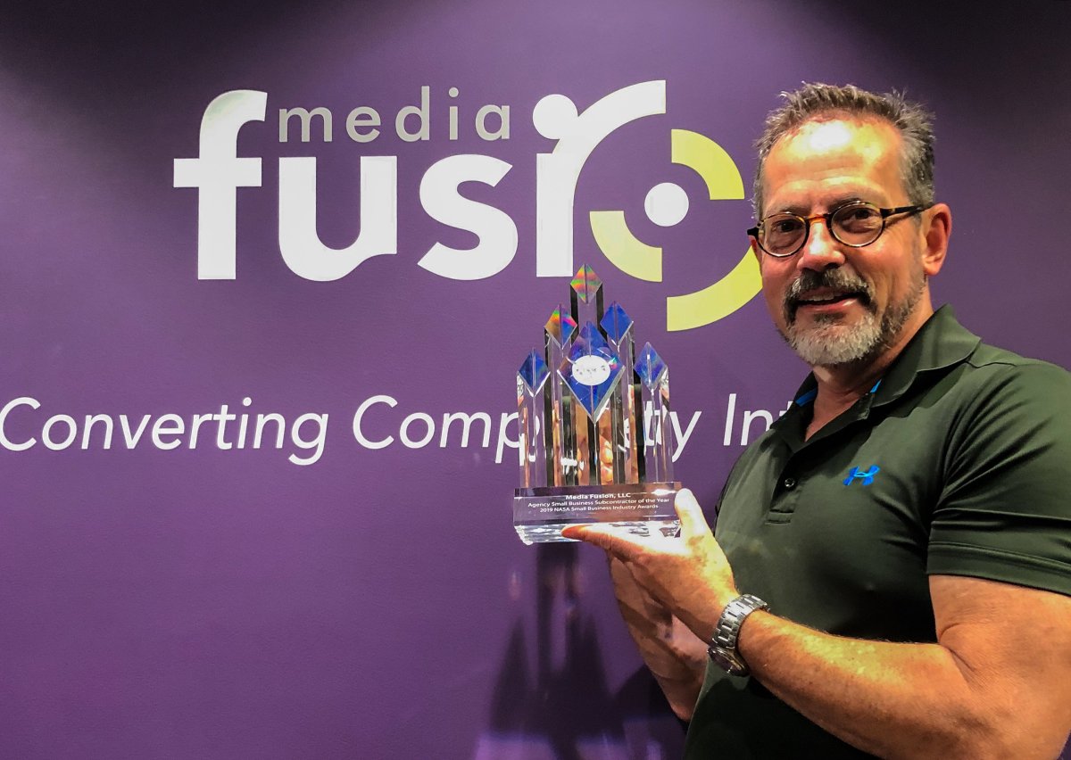 Media Fusion founder Tim McElyea holding a NASA Agency Small Business Subcontractor of the Year award Media Fusion founder Tim McElyea holding a NASA Agency Small Business Subcontractor of the Year award